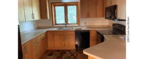 Kitchen with black appliances, parkay flooring, and light wood cabinets