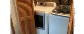 Laundry closet with side-by-side front load washer and top load dryer.