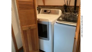 Laundry closet with side-by-side front load washer and top load dryer.