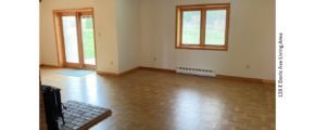 Living area with wood-burning stove, crank windows and light, wood parkay flooring