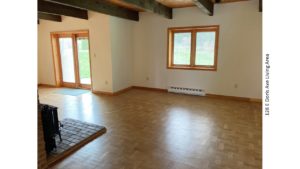 Living area with wood-burning stove, crank windows and light, wood parkay flooring