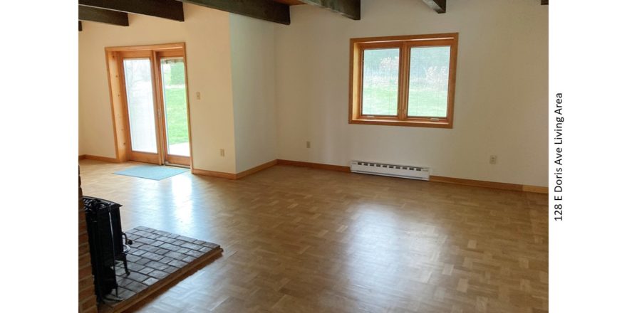 Living area with wood-burning stove, crank windows and light, wood parkay flooring