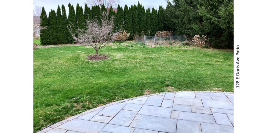 Back yard with lawn, small fenced in garden and patio