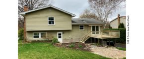 Back yard with lawn, deck and sunken patio with firepit.