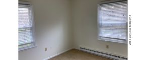 Unfurnished, carpeted bedroom with two windows