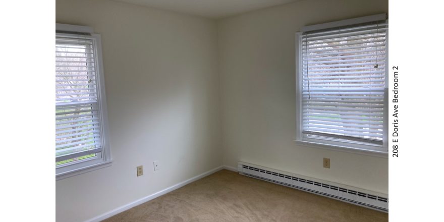 Unfurnished, carpeted bedroom with two windows