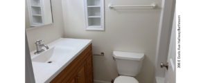 Bathroom with shower/tub combo, toilet, vanity and built-in shelves.