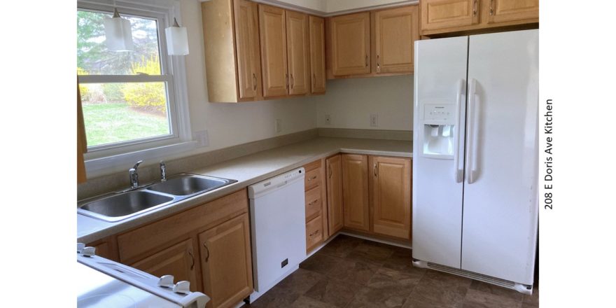 Kitchen with double sink, white appliances, and light wood cabinets