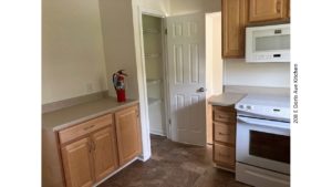 Kitchen with pantry, light wood cabinets, and white appliances