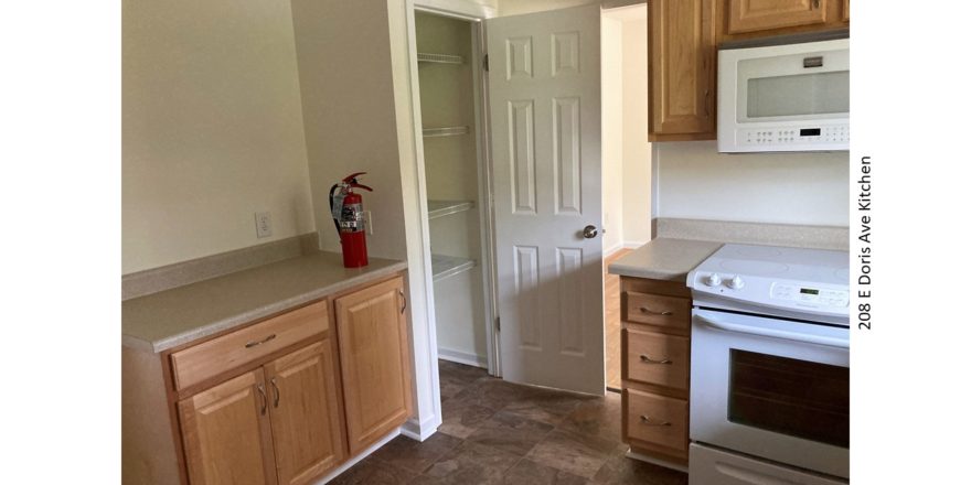 Kitchen with pantry, light wood cabinets, and white appliances