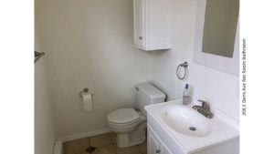 Bathroom with small vanity, toilet, mirror, and medicine cabinet above the toilet