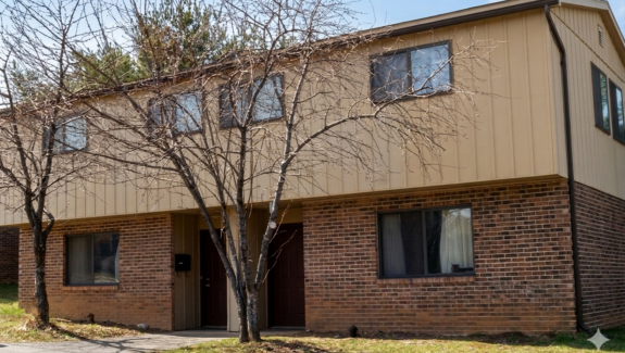 a two story brick building with trees in front of it