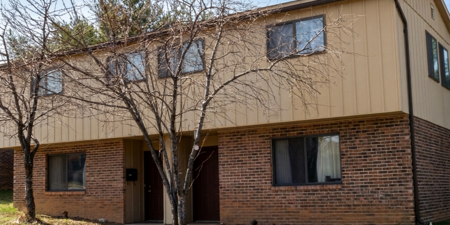 a two story brick building with trees in front of it