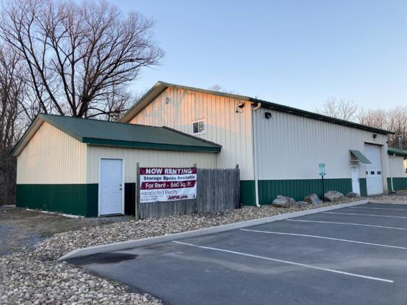 white and dark green building with garages