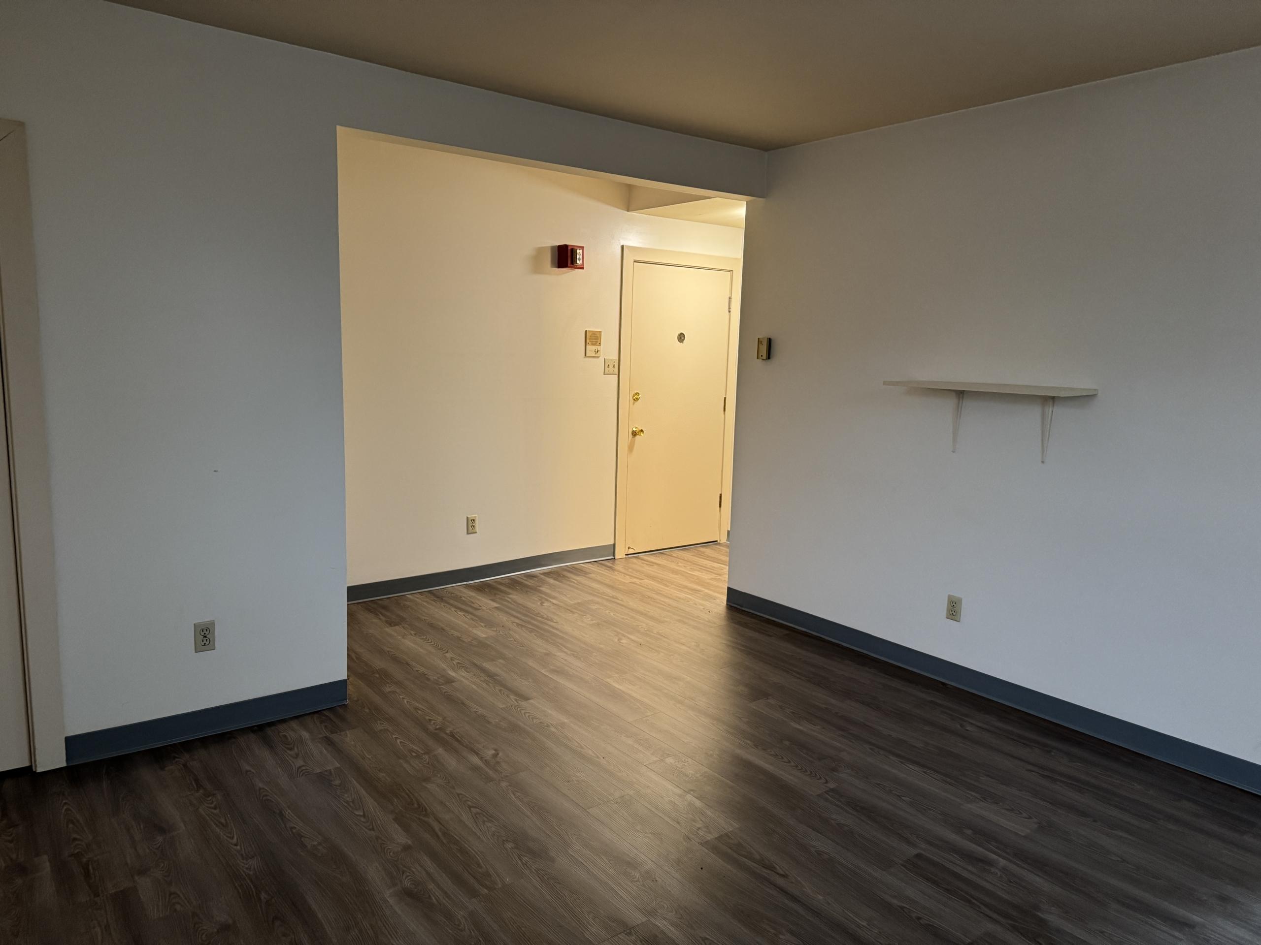 Empty room with wooden floors and white walls