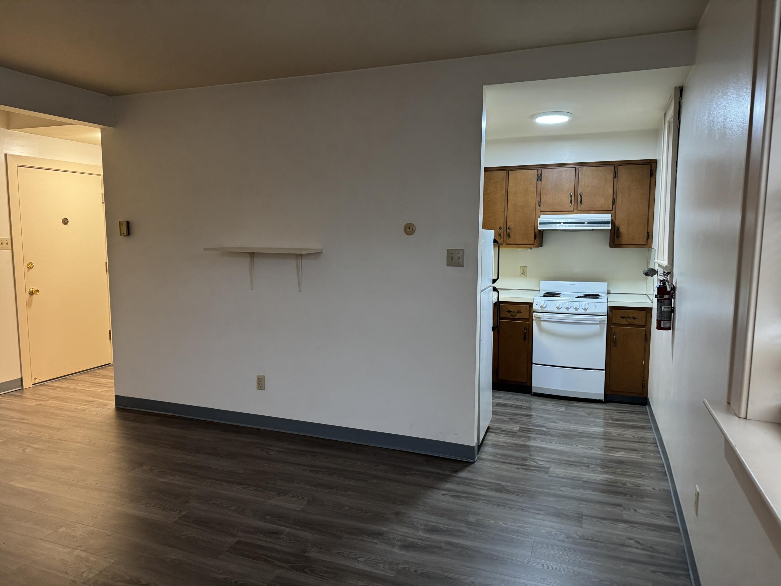 Empty kitchen with wooden cabinets and white appliances