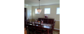 Furnished dining room with hardwood floors, area rug, and chandelier