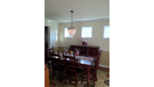 Furnished dining room with hardwood floors, area rug, and chandelier