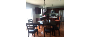 Kitchen with stainless steel appliances, large table and island with seating