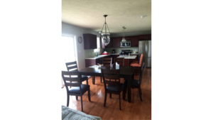 Kitchen with stainless steel appliances, large table and island with seating