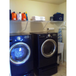 Laundry area with side-by-side washer and dryer and laundry tub.