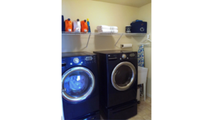 Laundry area with side-by-side washer and dryer and laundry tub.