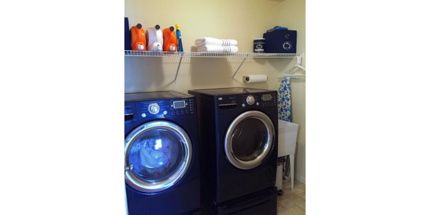 Laundry area with side-by-side washer and dryer and laundry tub.