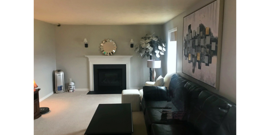 Carpeted, furnished living room with gas fireplace
