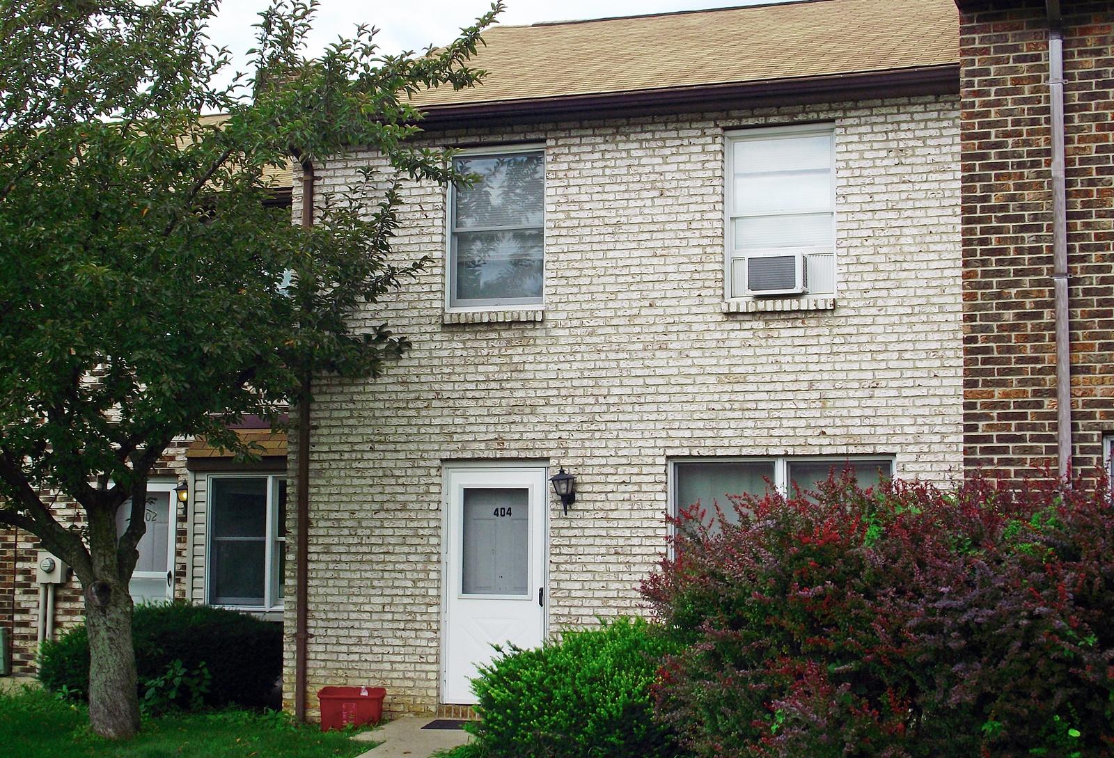 Tan brick townhouse at 404 Gerald St with white screen door