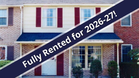 a red brick house with a blue ribbon in front of it