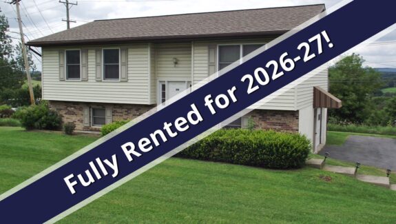 a house for sale with a blue ribbon in front of it