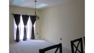 Carpeted dining area with chandelier and skylights