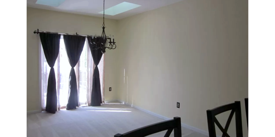 Carpeted dining area with chandelier and skylights