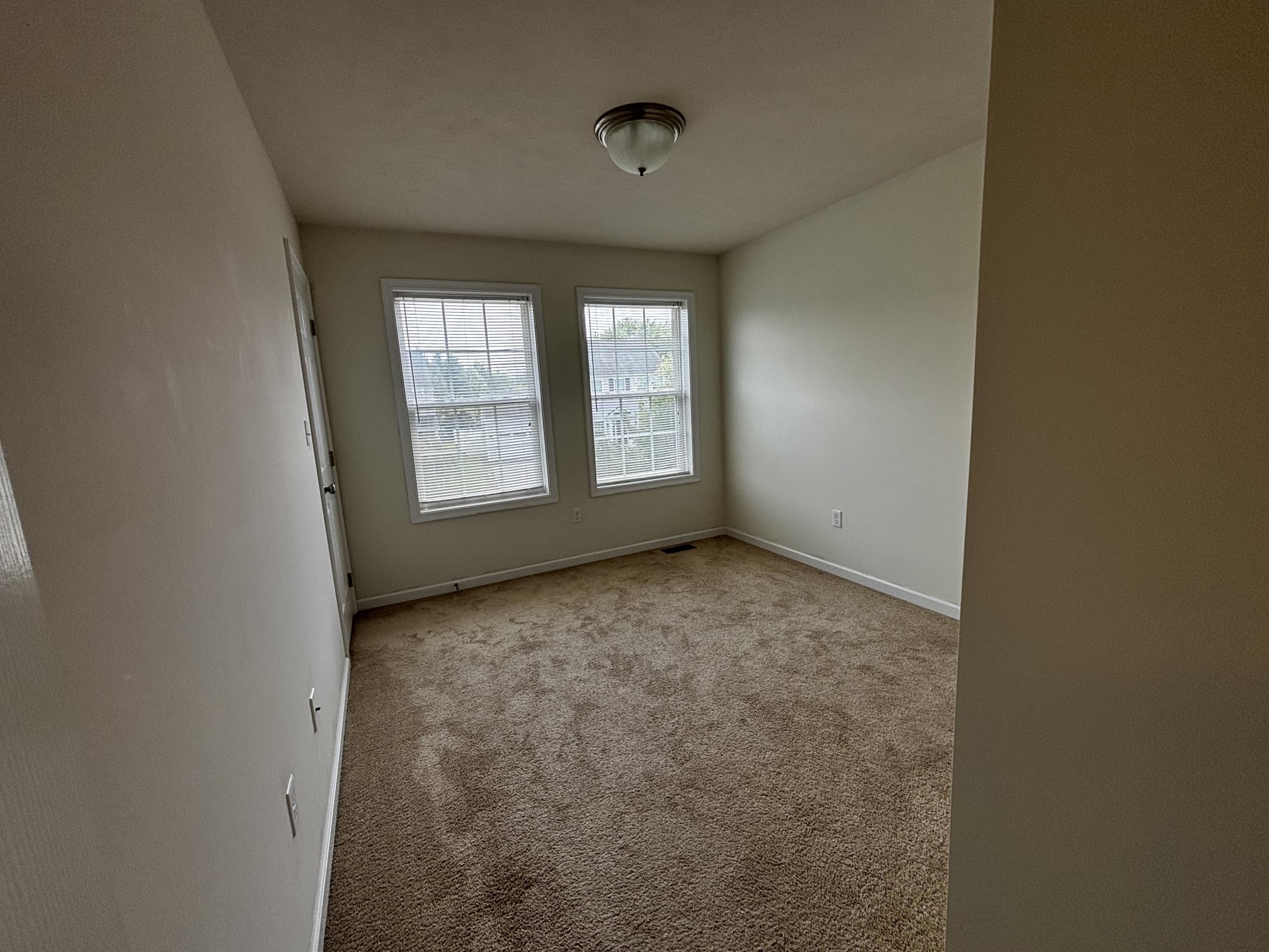 Empty bedroom with neutral carpet and blinds