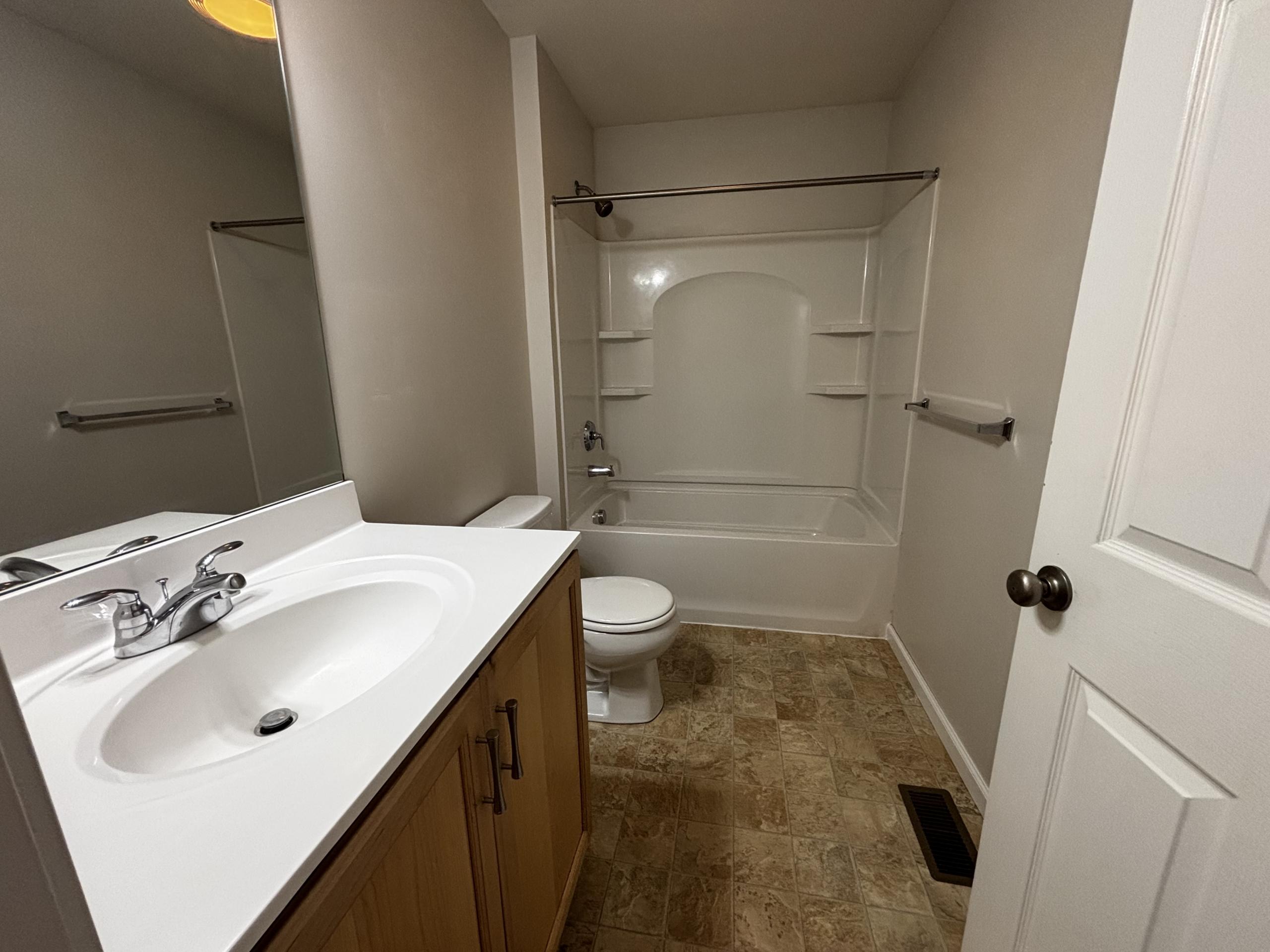 Bathroom with vanity, toilet, and tub
