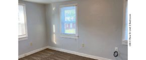 Unfurnished, carpeted bedroom with two windows