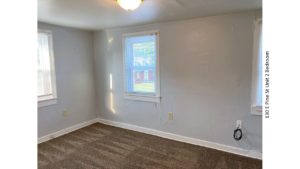 Unfurnished, carpeted bedroom with two windows