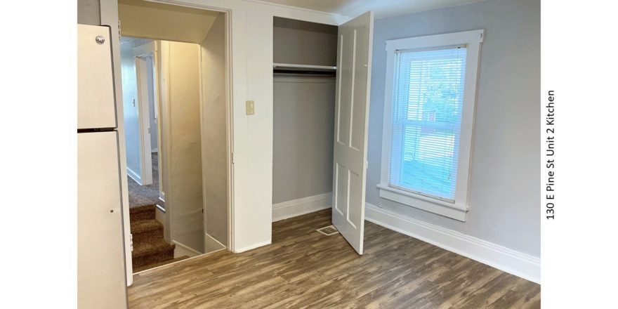 Unfurnished Kitchen with wood-style flooring and a fridge