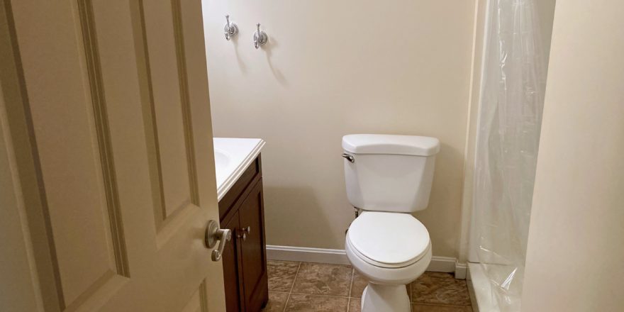 Bathroom with shower stall, vanity, and toilet