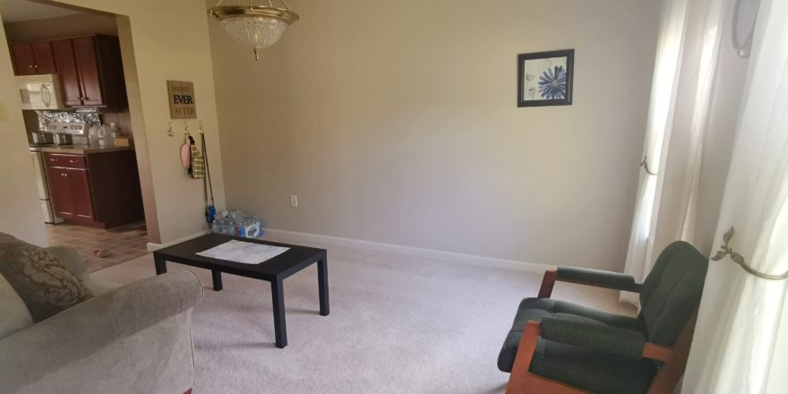 Carpeted living room with coffee table and seating