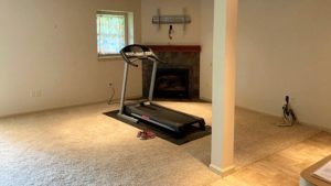 Basement with workout equipment and fireplace