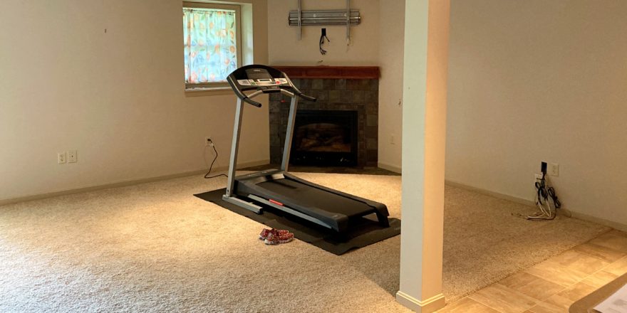 Basement with workout equipment and fireplace