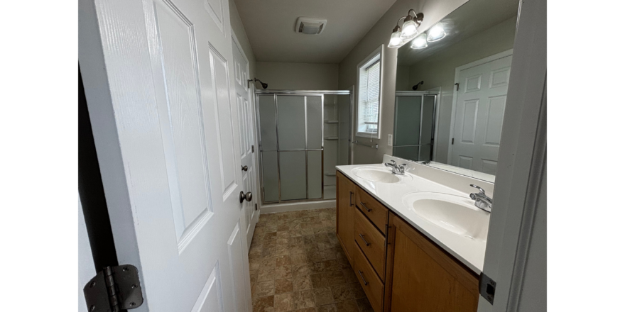 a bathroom with a sink, mirror, and shower