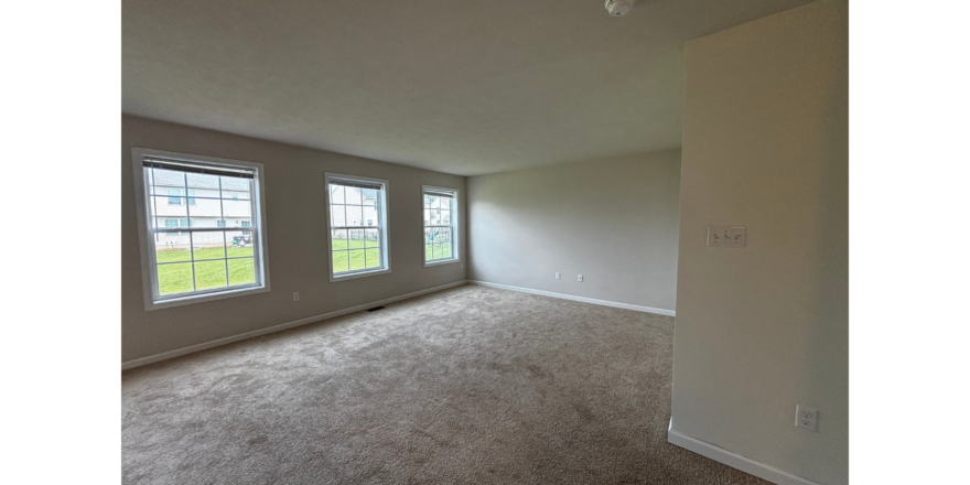 an empty room with three windows in it