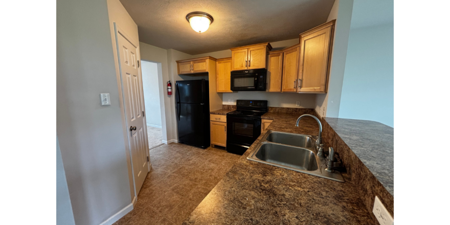 a kitchen with granite counter tops and black appliances
