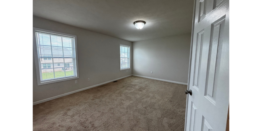 an empty room with a door leading to another room