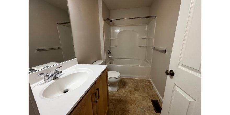 a bathroom with a toilet, sink, and shower