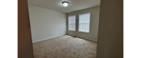 an empty room with carpet and a window