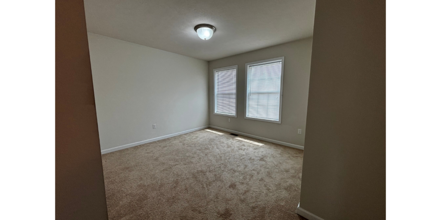 an empty room with carpet and a window