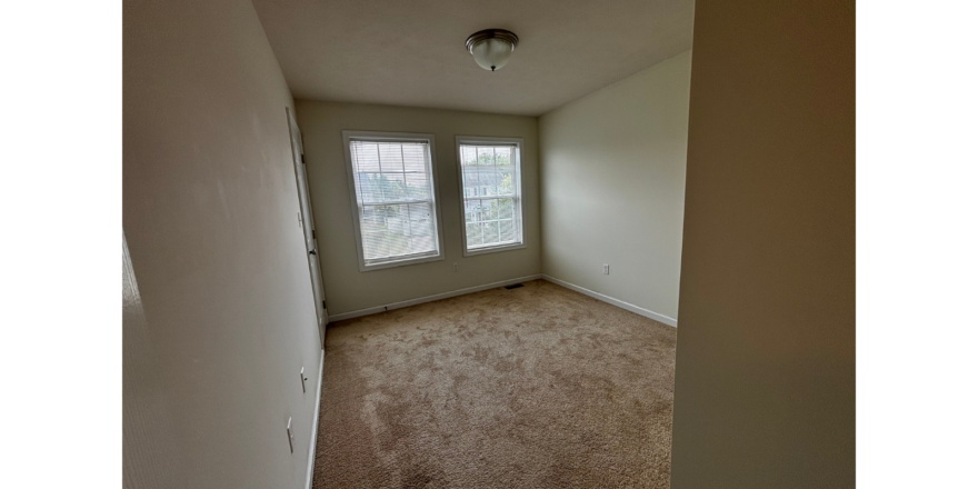 an empty room with a door leading to a window